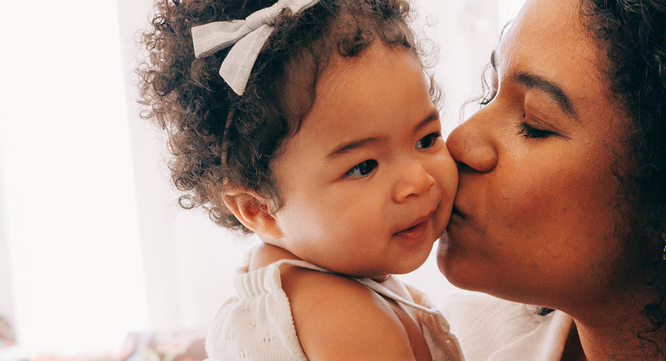 Mother kissing baby on cheek